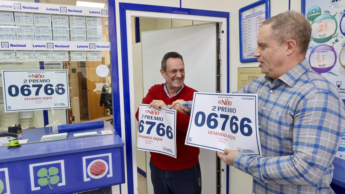 MURCIA, 06/01/2025.- El propietario de la administración L'Agustinica en el Paseo Florencia de Murcia, Pepe Imbernón (i), muestra el número premiado con el segundo premio del sorteo de la lotería del Niño, del que ha vendido 10 décimos. EFE/ Marcial Guillén