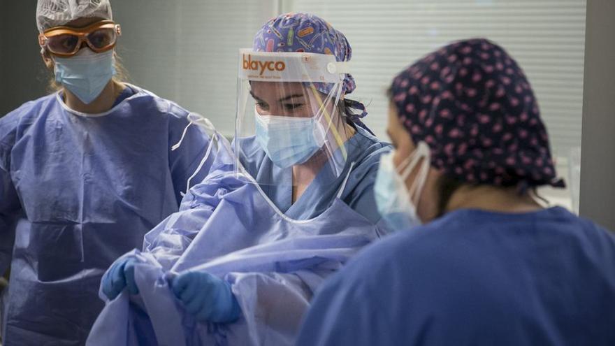 Sanitarios quitándose los trajes de protección tras atender a pacientes covid-19.