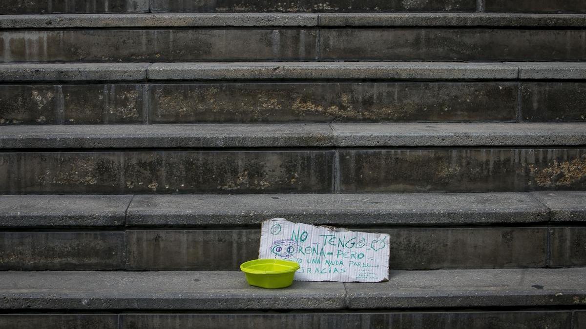 Un cartel de una persona pidiendo ayuda en una calle de Alicante, en imagen de archivo