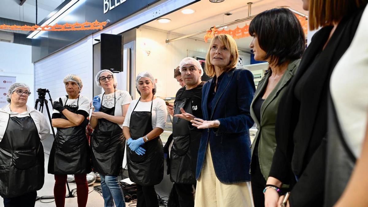 La presidenta de la Diputació de Barcelona, Lluïsa Moret; y la diputada del ente, Olga Serra, conversan con los aprendices de la formación para paradistas de mercados