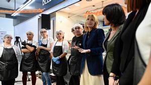 La presidenta de la Diputació de Barcelona, Lluïsa Moret; y la diputada del ente, Olga Serra, conversan con los aprendices de la formación para paradistas de mercados