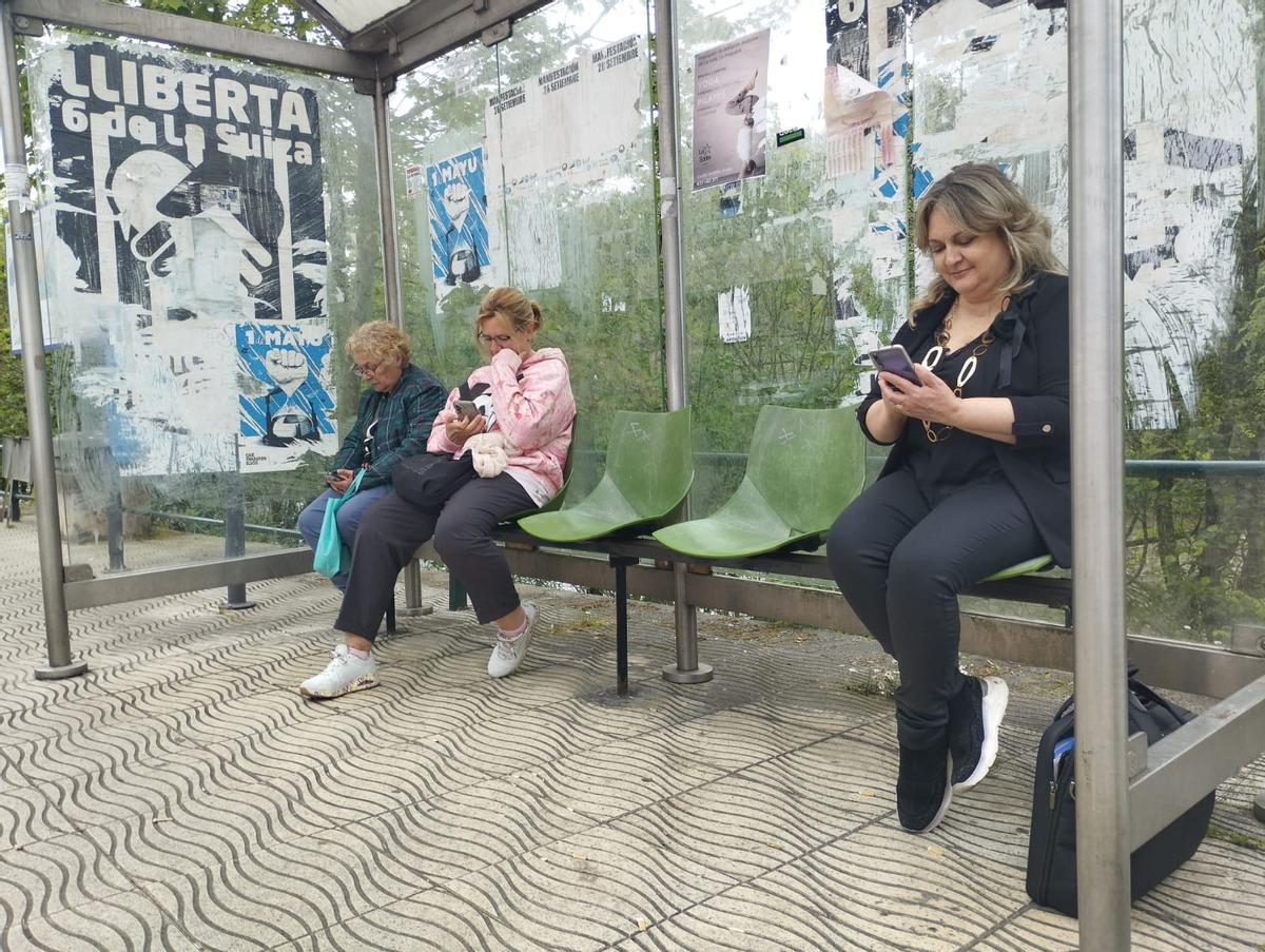 Maribel Menéndez, a la derecha, y Amparo Fernández, en el centro, esperando el autobús en Sama.