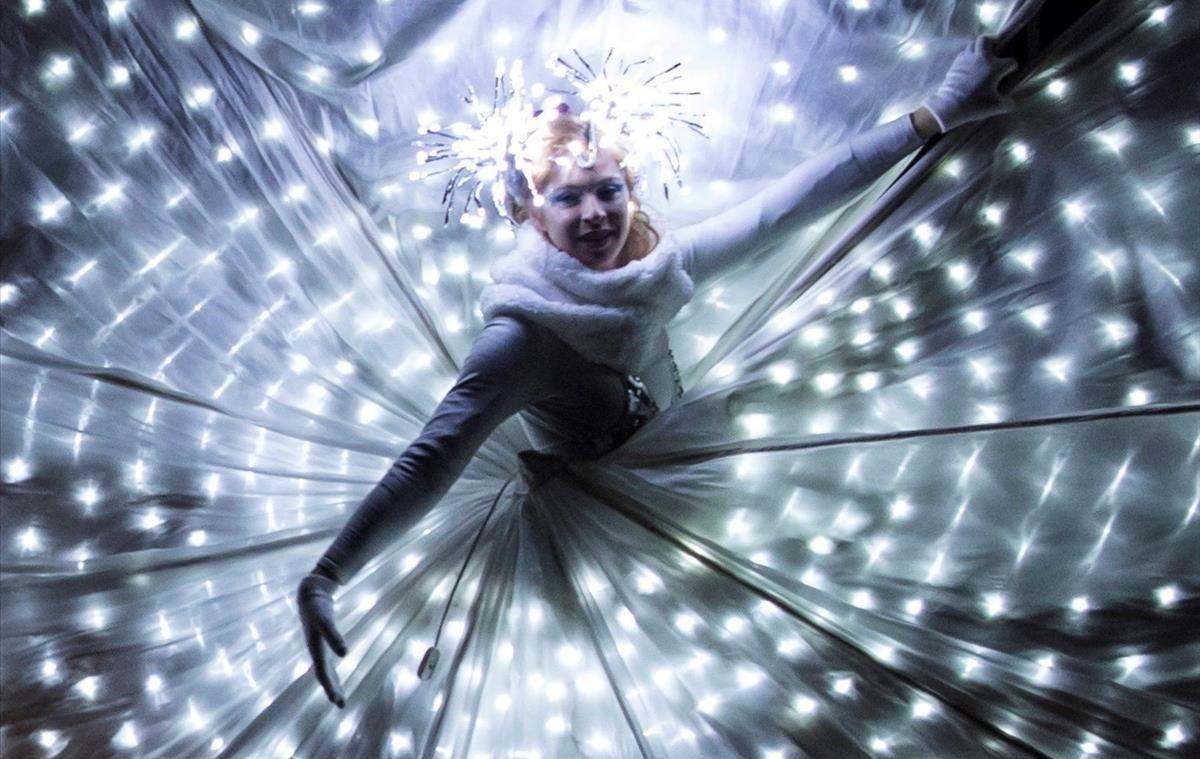 Una mujer usa un vestido cubierto con luces durante el primer día del Festival de Luces de Morat, Suiza.