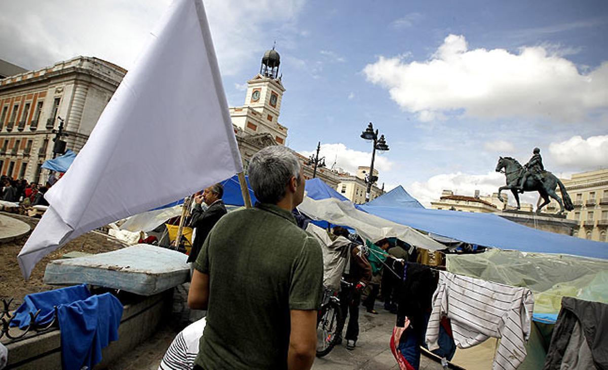 Un home sosté una bandera blanca aquest dijous a la Puerta del Sol.