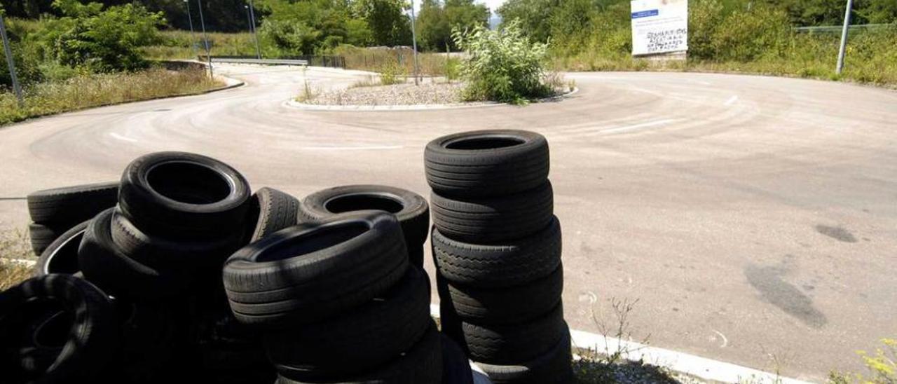 Neumáticos acumulados en las inmediaciones de la planta de Baldajos, con la Moral II al fondo.