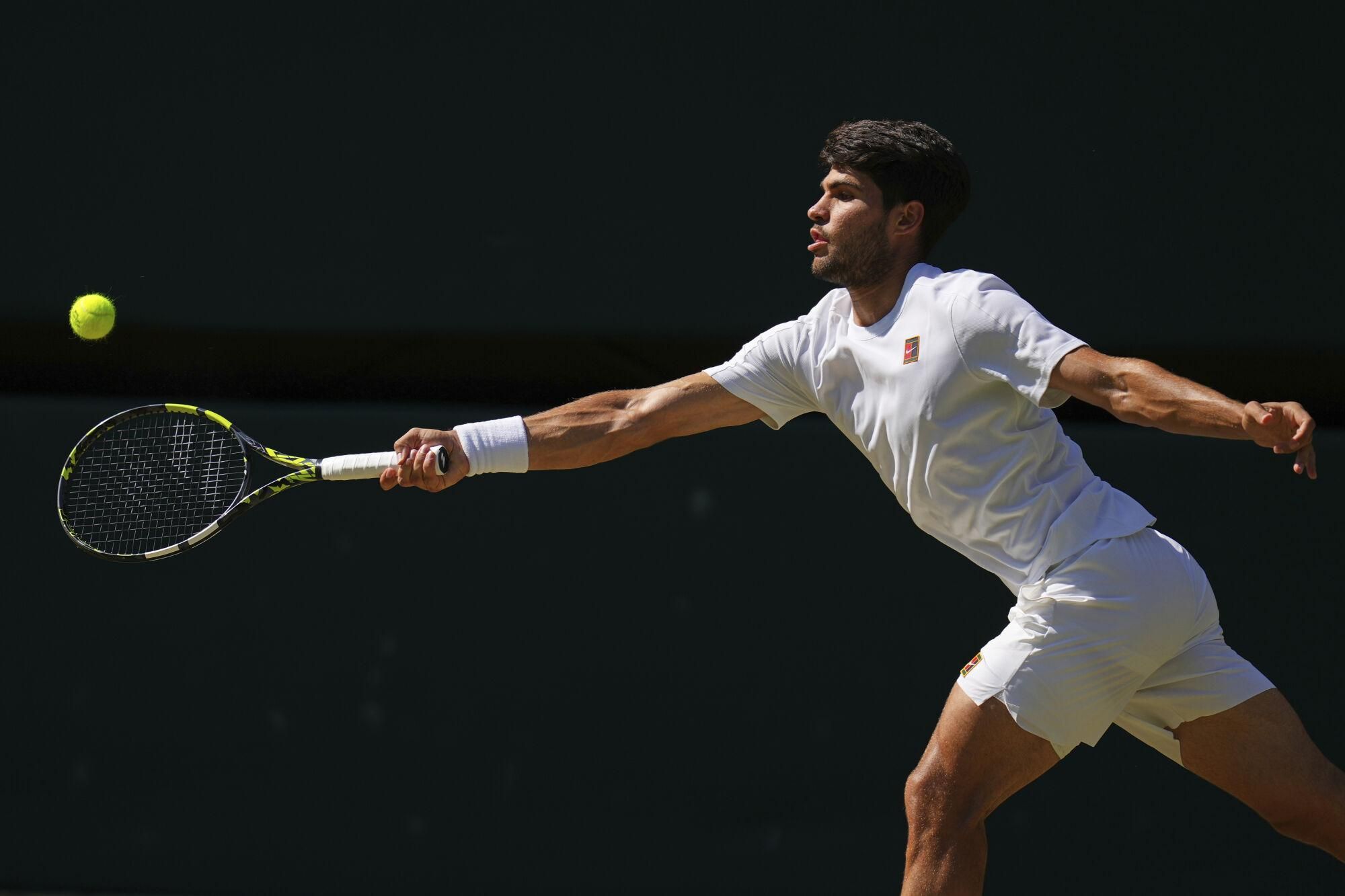 Carlos Alcaraz of Spain returns to Taylor Fritz of the U.S. during the men's semifinal singles match at the Wimbledon Tennis Championships in London, Friday, July 11, 2025.(AP Photo/Kirsty Wigglesworth)
