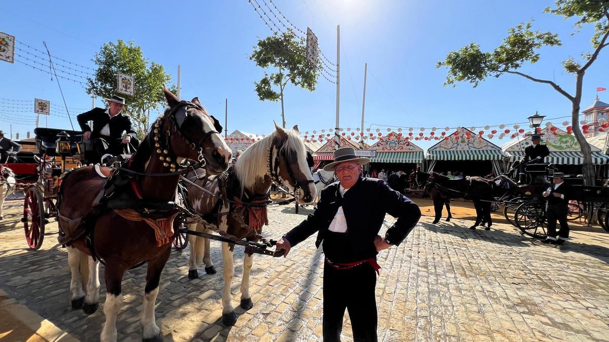 Juan Oliva posa junto a su coche de caballos en el Real de la Feria de Sevilla