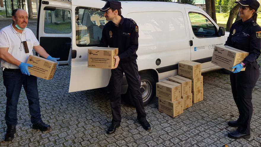 La Policía Nacaional de Vigo haciendo entrega del material recaudado a un empleado de Atención Primaria. // PN