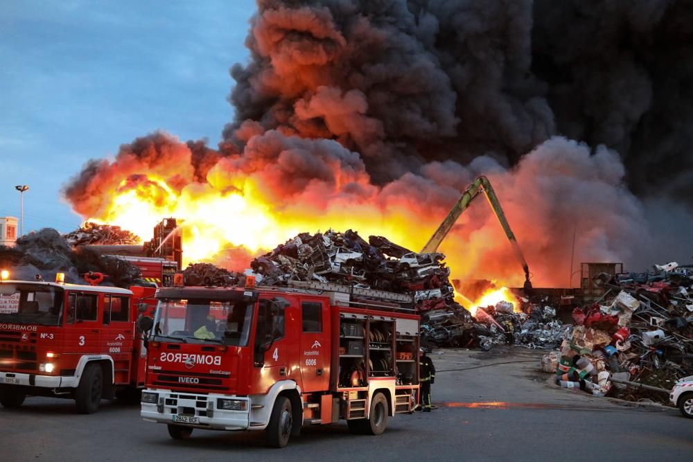 Labores de extinción del incendio de un desguace en Gijón