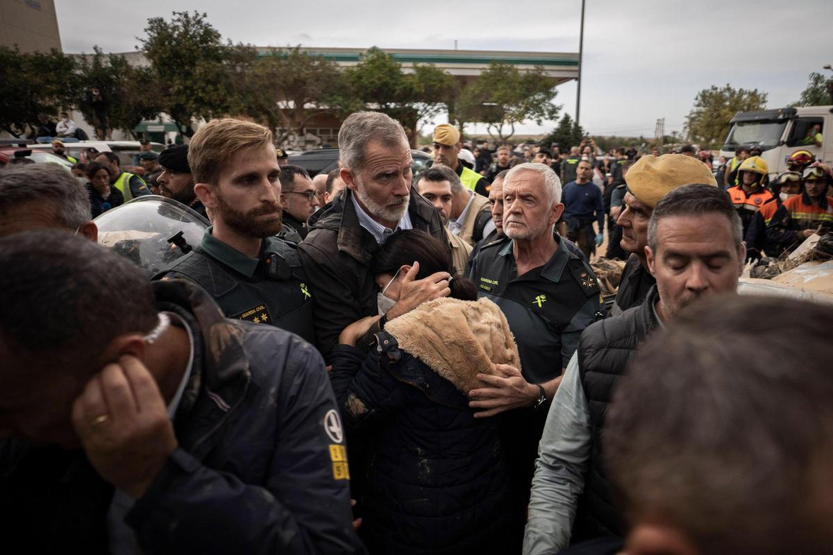 El rey Felipe VI consuela a una mujer durante su visita a Paiporta (Valencia).