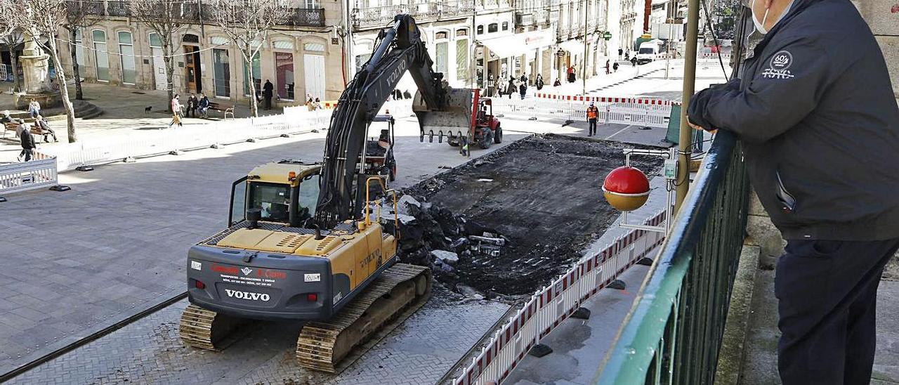 Un peatón observa los trabajos de retirada del empedrado en Porta do Sol.