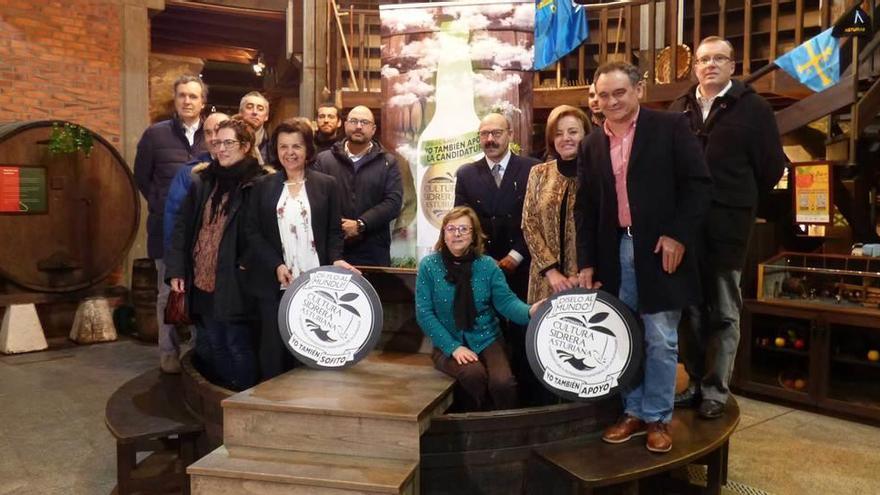 A la izquierda, miembros del comité director tras la consejera María Jesús Álvarez, con la publicidad de la campaña. A la derecha María Jesús Aguilar, Jorge Uría, Otilia Requejo, Juan Cañal (alcalde de Nava) y Tino Cortina (presidente del consejo regulador de la DOP).