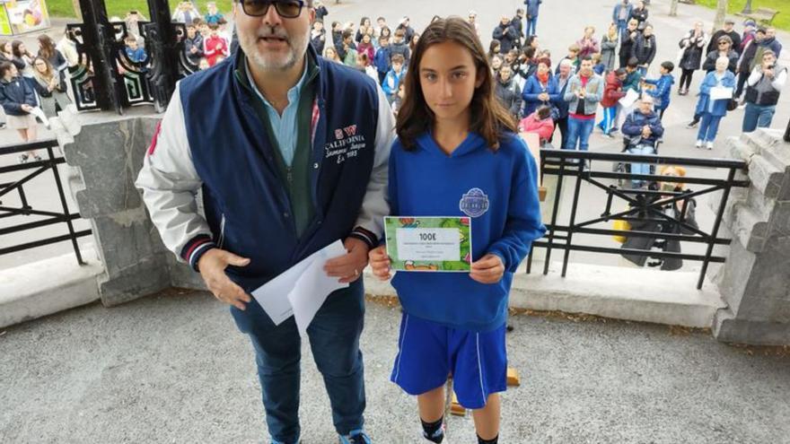 El alcalde de Langreo, Roberto García, con la ganadora del concurso de marcapáginas en el concejo, Iria Gutiérrez.