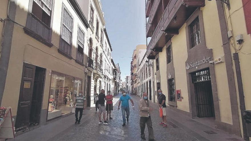 Varias personas pasean por la calle.