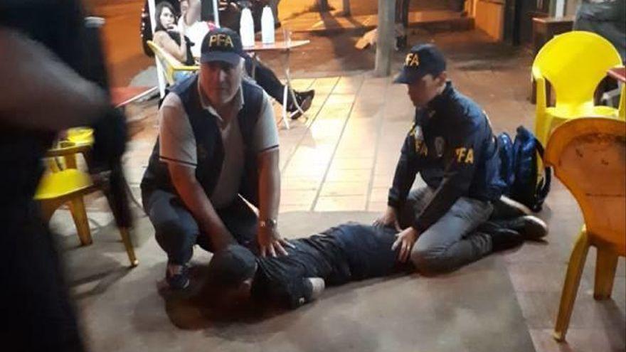 Dos agentes de la Policía Federal inmobilizan al hombre en Argentina.