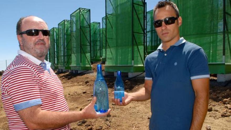 Ricardo Gil (i) y Theo Hernando sujetan un prototipo del envase que van a comercializar con agua de niebla. | santi blanco