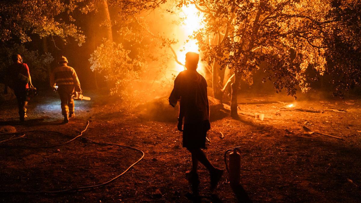 Varias personas trabajan en las labores de extinción del incendio forestal, a 26 de julio de 2026, en La Adrada, Ávila, Castilla y León (España). La Adrada, uno de los municipios del Valle del Tiétar (Ávila), ha sido evacuado de forma preventiva este sábado ante el avance del grave incendio de Burgohondo que, junto con el de Madrid, tienen en vilo a la población aledaña y que han quemado ya más de 45.000 hectáreas. 26 JULIO 2026 INCENDIO FORESTAL;PIXELADA