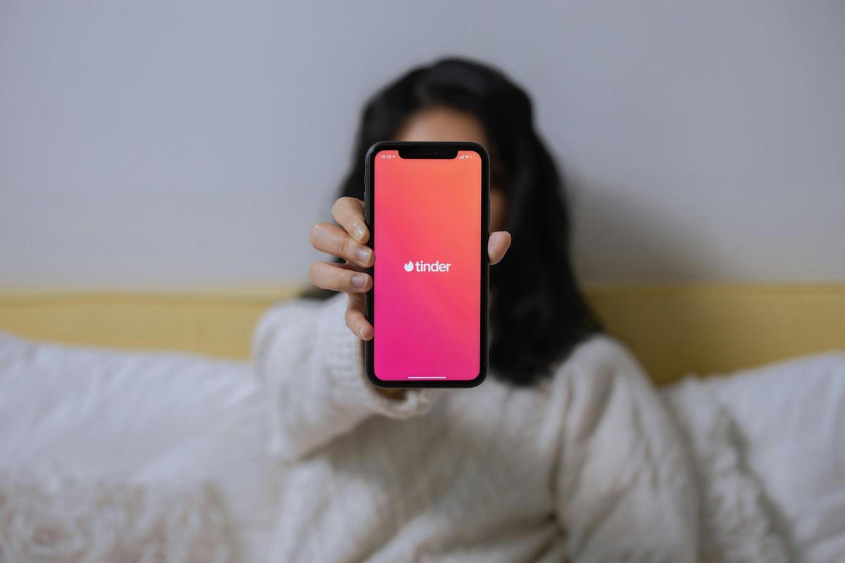 Una joven muestra la app de Tinder en su móvil