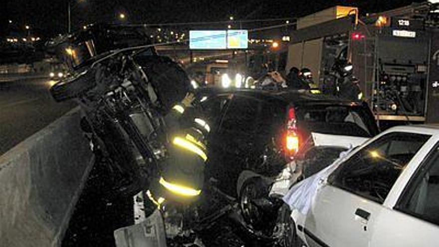 Un bombero trabajando entre varios de los vehículos implicados en el accidente ocurrido ayer tarde en el kilómetro 3 de la M-11, en sentido entrada a Madrid.