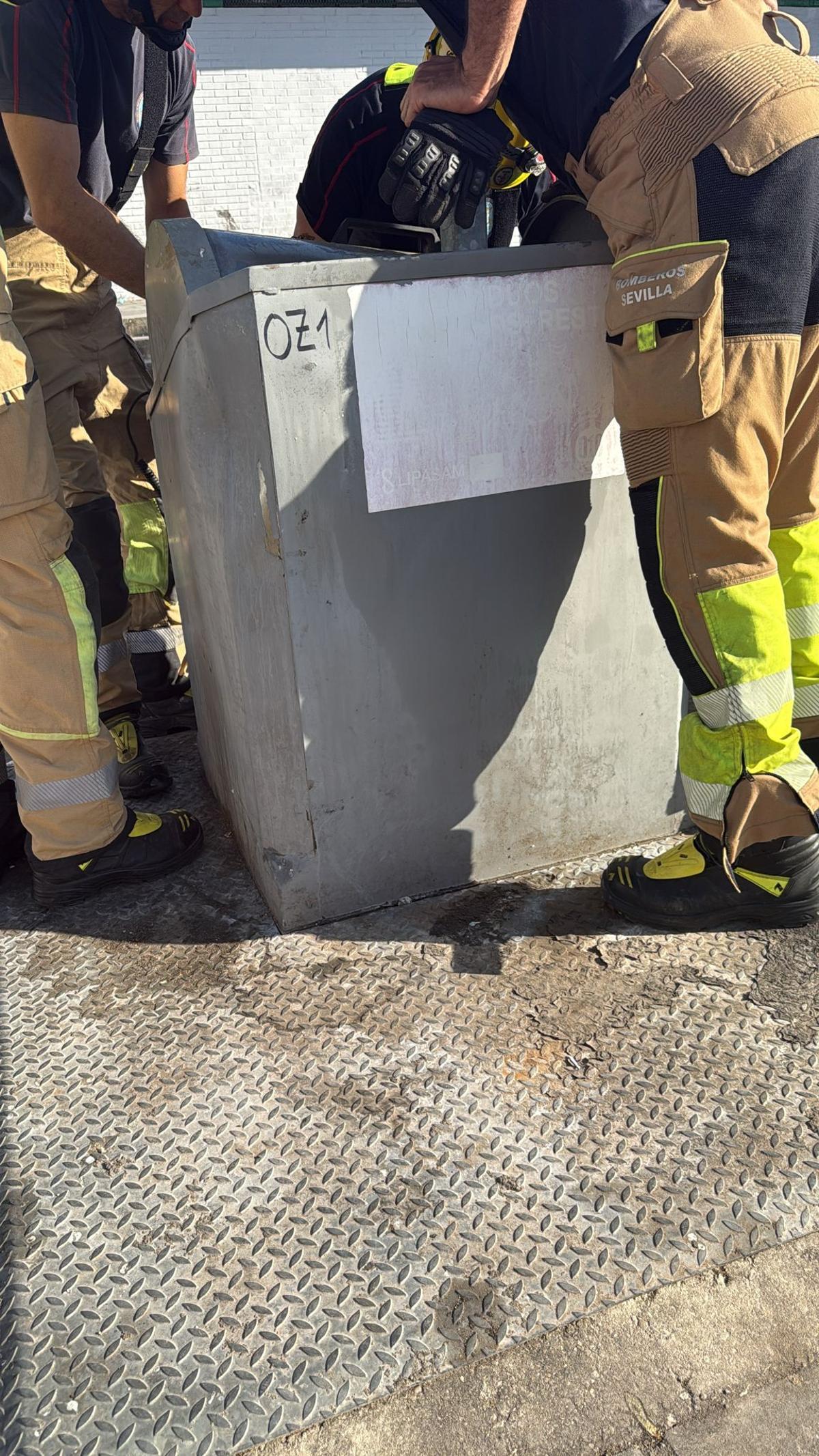 Los bomberos trabajando en el contenedor soterrado.