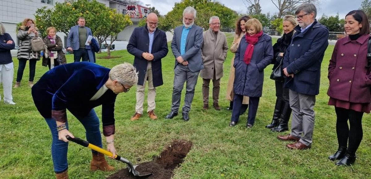 La consejera enterrando la cápsula del tiempo en el San Agustín ante la mirada de responsables políticos y gestores sanitarios.