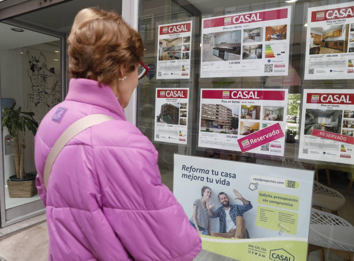 Una mujer, ante los carteles de una inmobiliaria en Fernández Balsera. | LNE