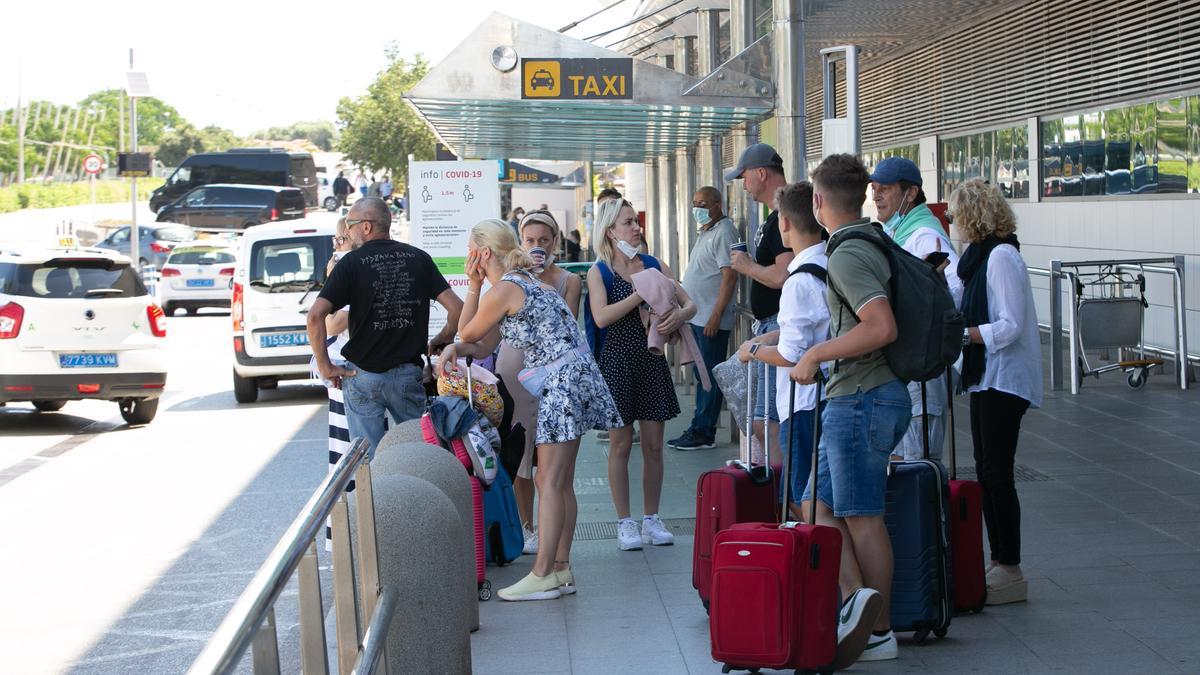 Turistas esperando en la parada del aeropuerto.