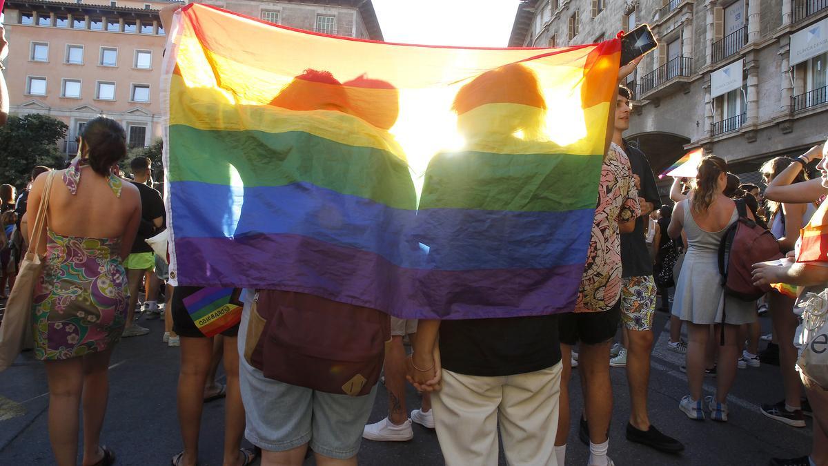 Un grupo de jóvenes envueltos en la bandera LGTBI
