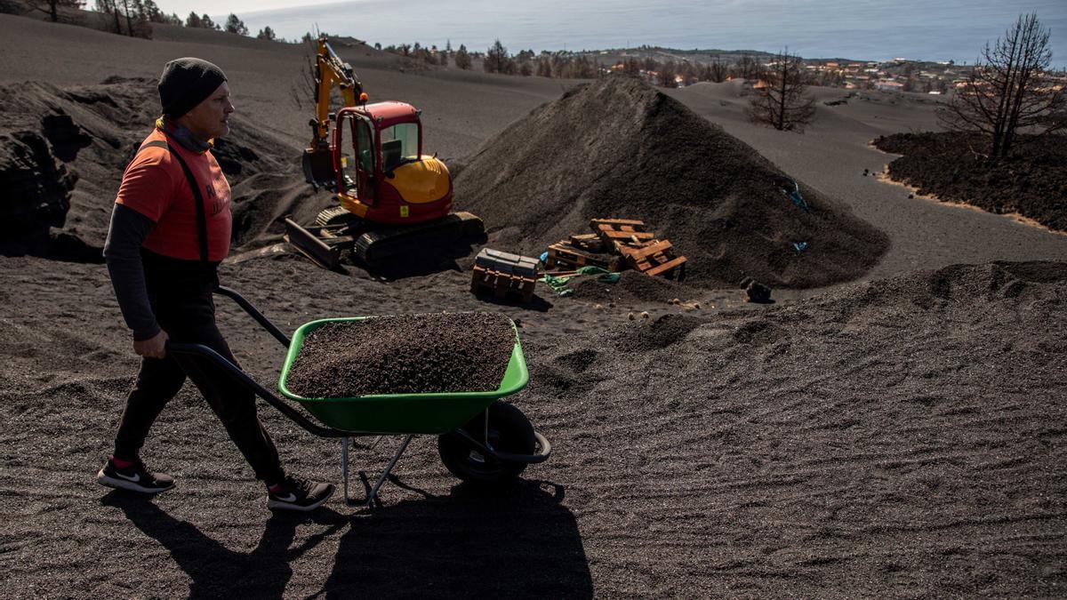 Vicente Leal transporta una carretilla llena de ceniza a 17 de febrero de 2022 en Las Manchas, El Paso, La Palma, Canarias, España. La casa de Vicente Leal, que es su segunda residencia, es la más próxima al cono volcánico del volcán de La Palma y tras 85