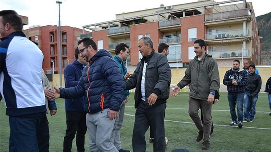 Padres de jugadores de dos equipos se dan la mano antes de un partido.