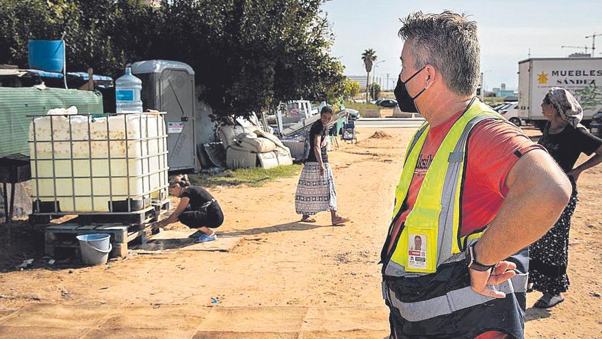 Conor Hannah observa el bidón instalado en el  asentamiento de San Marcelino y cómo las mujeres  se van las manos.