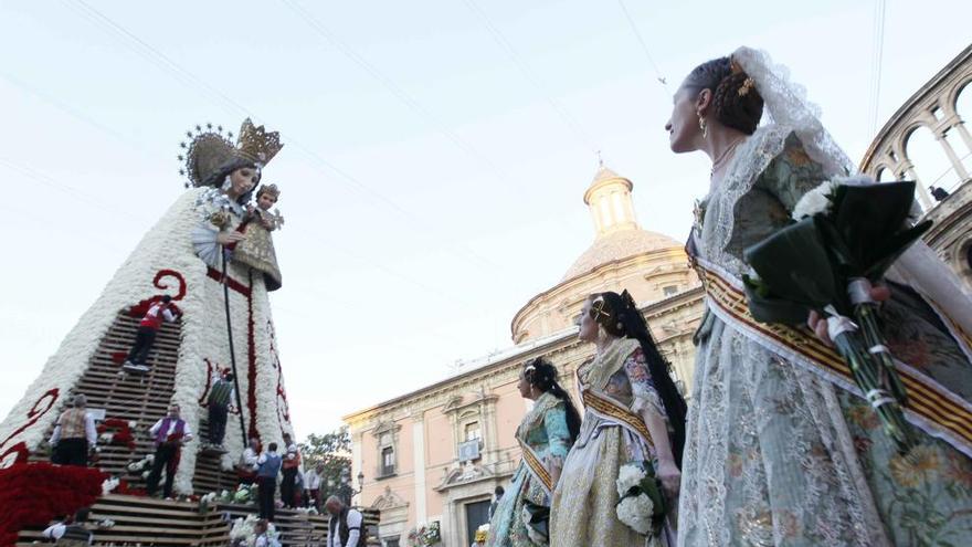 Tres falleras observan el manto floral de la Virgen de los Desamparados