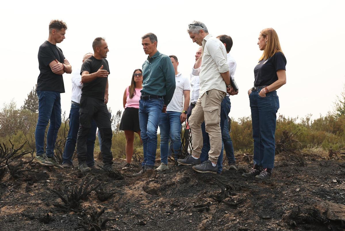 El presidente del Gobierno, Pedro Sánchez (c), y el ministro del Interior, Fernando Grande-Marlaska (2d), durante su visita a las zonas afectadas por los incendios forestales, a 17 de agosto de 2025, en Villablino, León, Castilla y León (España).