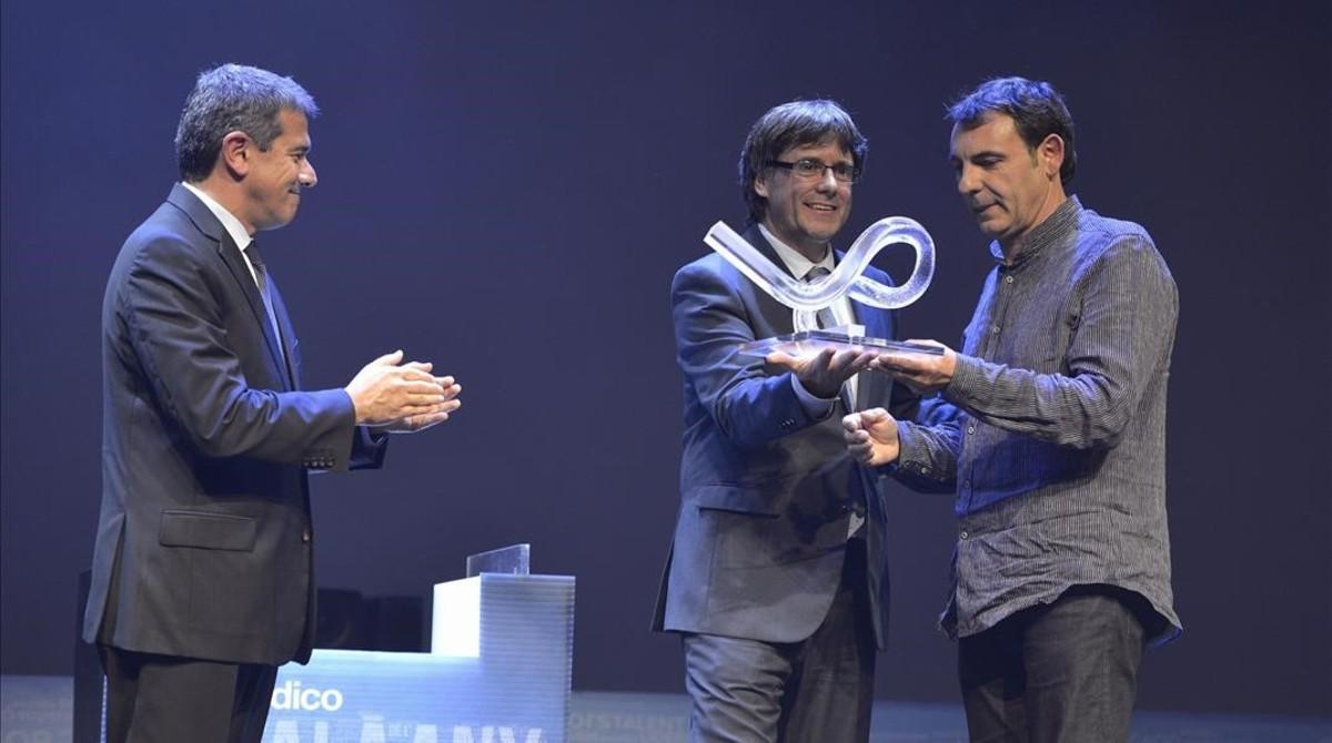 Òscar Camps recibe el premio de manos del ’president’ Carles Puigdemont en presencia de Agustí Cordón.