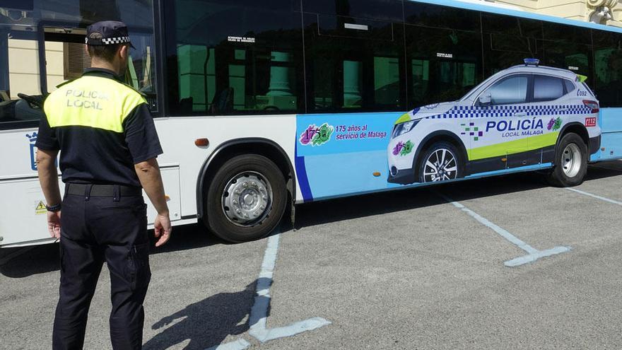 Un agente, frente a uno de los autobuses de la EMT.