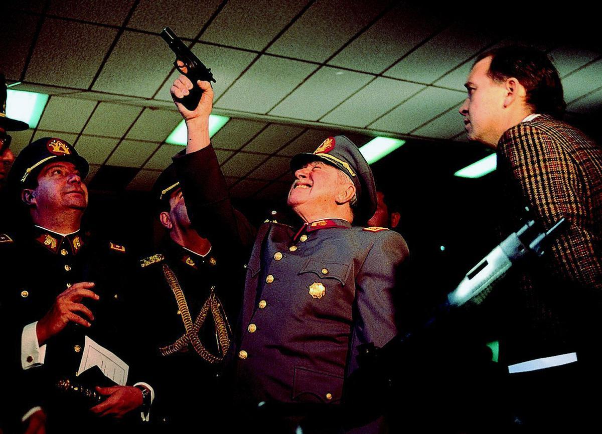 ** FILE ** Gen. Augusto Pinochet, center, checks a pistol during a visit to an arms factory, in Santiago, Chile, on Aug. 14, 1994. Pinochet, the fierce anti-communist dictator who ruled Chile with an iron fist from 1973 to 1990, died Sunday, Dec. 10, 2006 from heart complications, the Santiago Military hospital reported. He was 91. (AP Photo/John Perez). AUGUSTO PINOCHET , VISITA , ARMAMENTO , FABRICA , PISTOLA , PISTOLAS _ GENERAL, PLANO