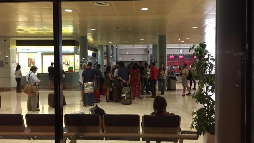 Pasajeros afectados por la cancelación del vuelo a Barcelona, anoche, esperando para efectuar una reclamación.