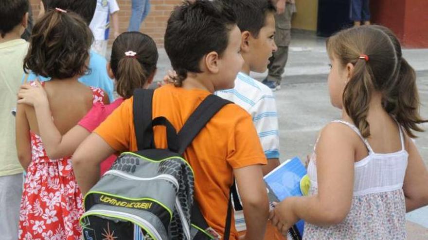 Un grupo de niños hace cola para entrar a las clases de un colegio.