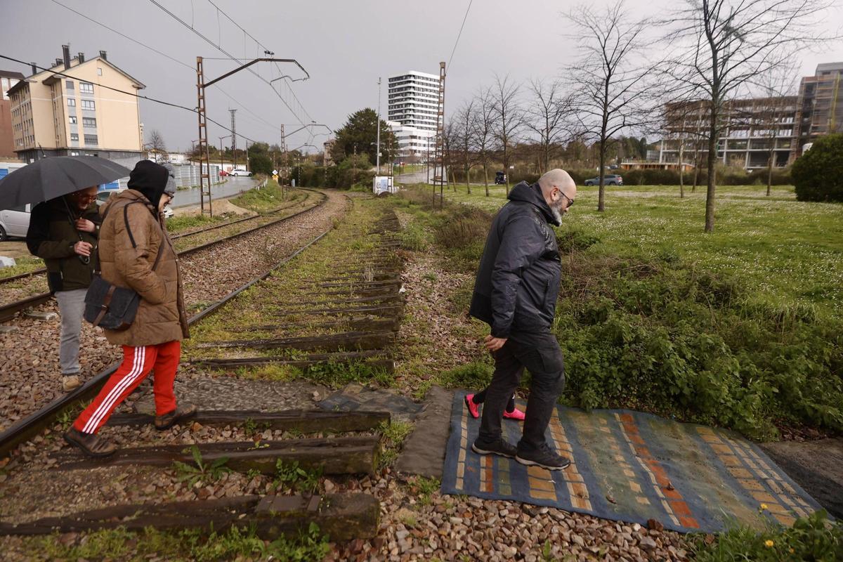 Vecinos cruzando las vías en El Lauredal.