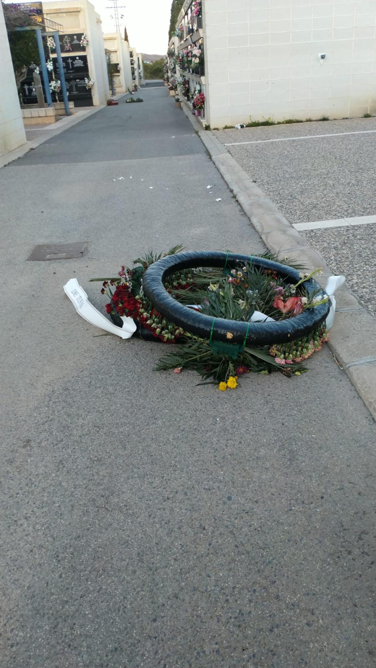 Una corona en el Cementerio Nuevo, en mitad de una calle, al fondo se observan más flores caídas