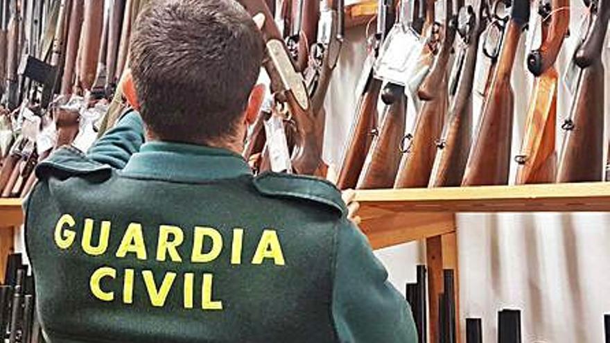 Un agente examina las armas. | GUARDIA CIVIL