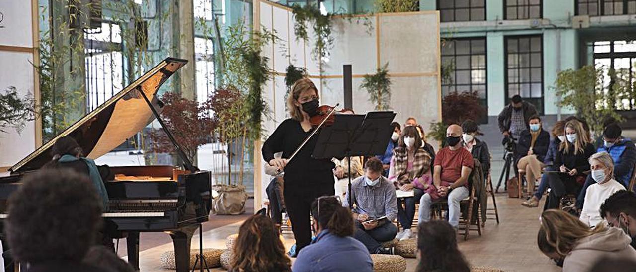 Lohez, al violín, rodeada de público, en el taller de La Vega. | Miki López