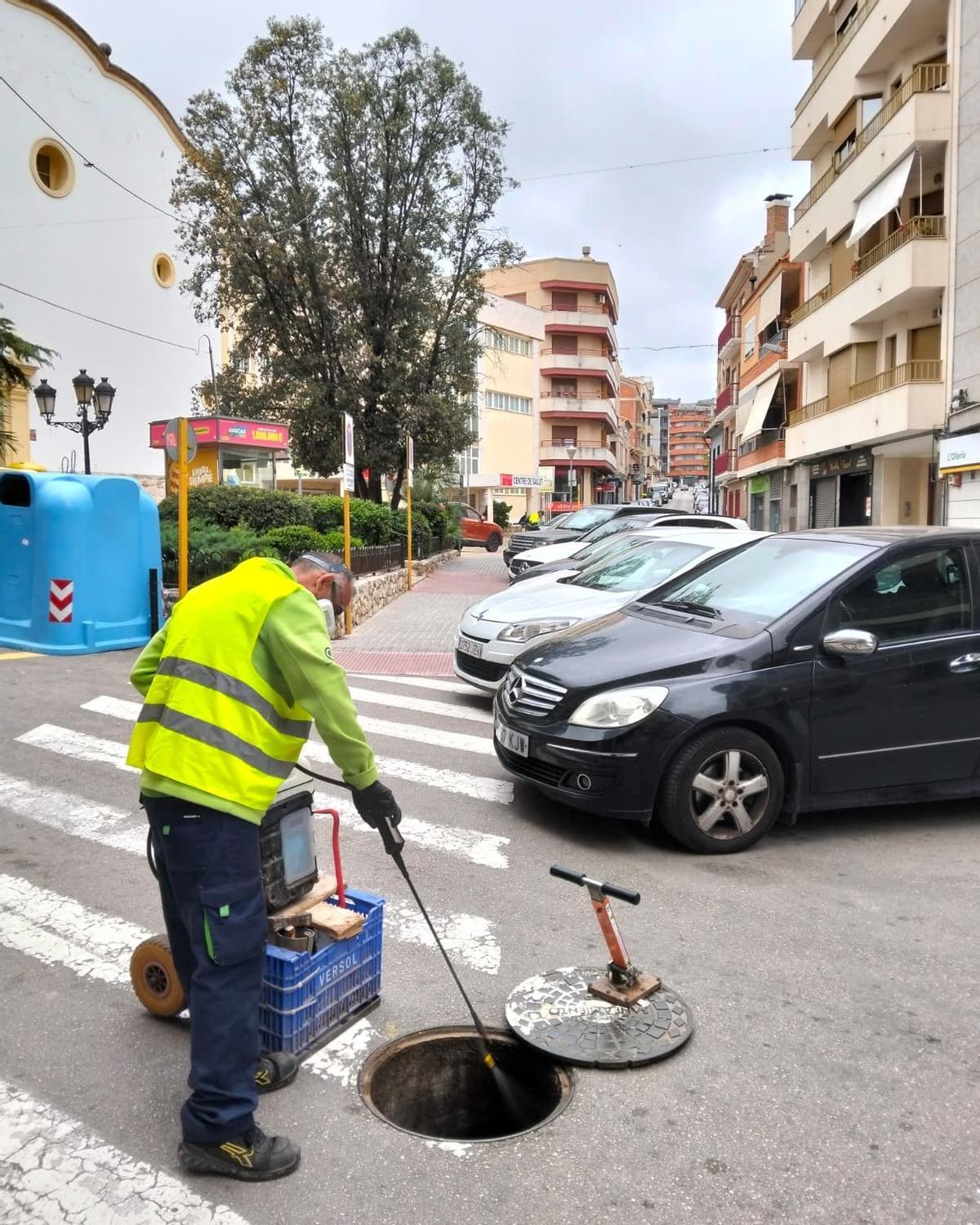 Un operario aplicando el tratamiento contra las plagas en una alcantarilla de l'Olleria.