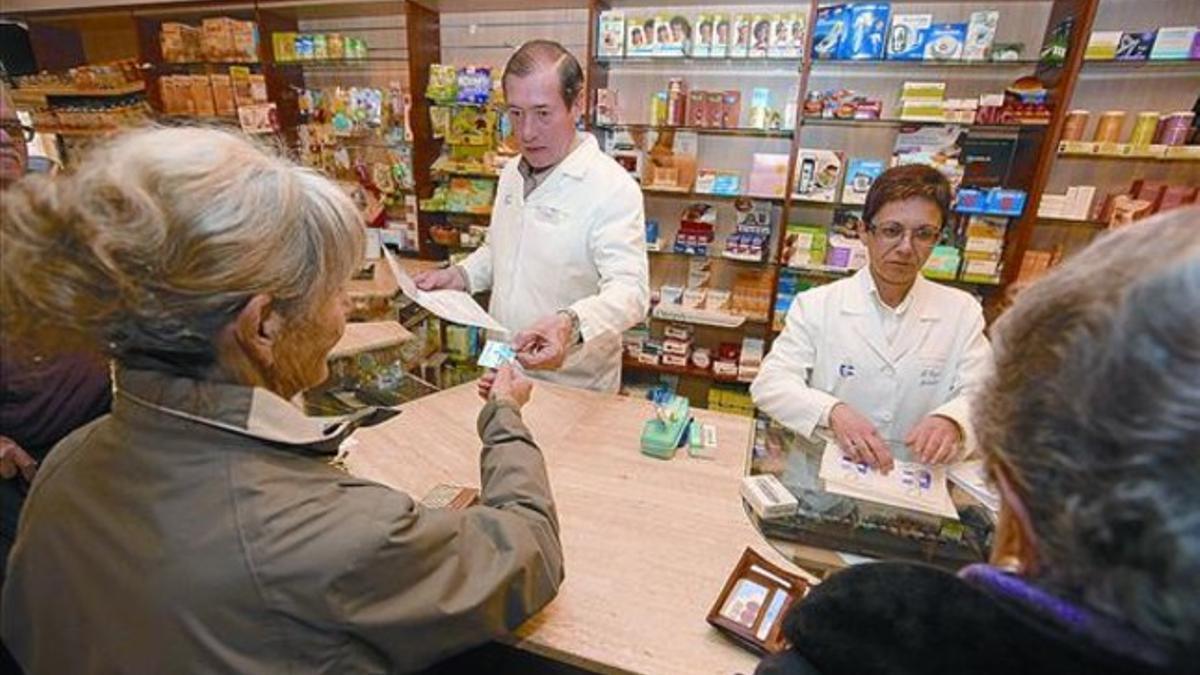 Dos mujeres retiran medicamentos en una farmacia de Barcelona.