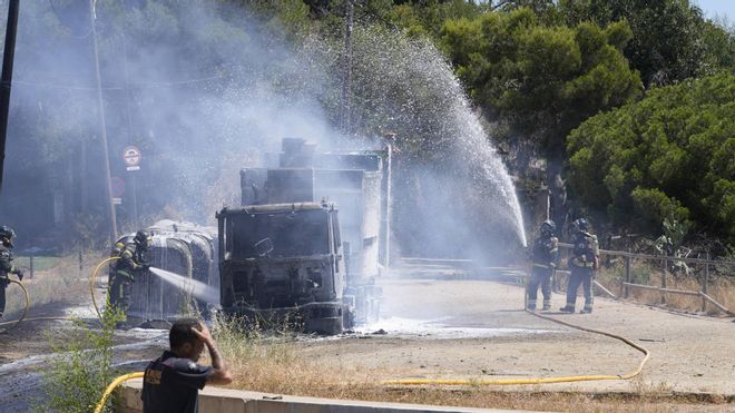Tareas de extinción de un camión de recogida de basura que se ha incendiado en Torre Baró