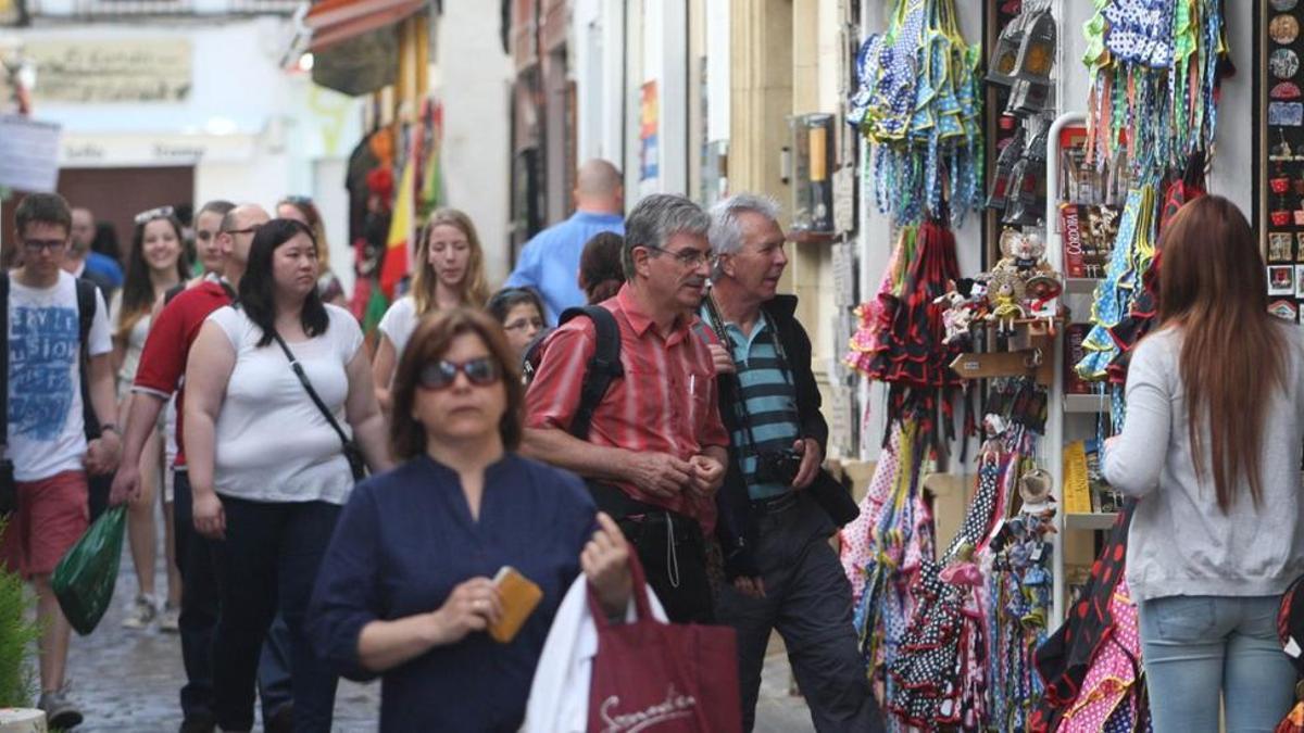 Turistas pasean ante los comercios en una calle de La Judería en Córdoba.