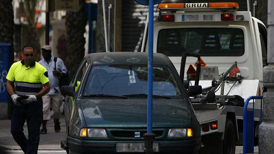 Un coche es retirado por la grúa en una imagen reciente.