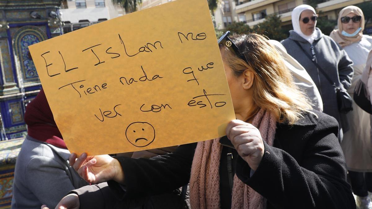 Una mujer sostiene una cartulina con un lema defendiendo el islam, en el sitio donde un hombre de origen marroquí asesinó al sacristán Diego Valencia de la iglesia de la Palma en Algeciras (Cádiz). /