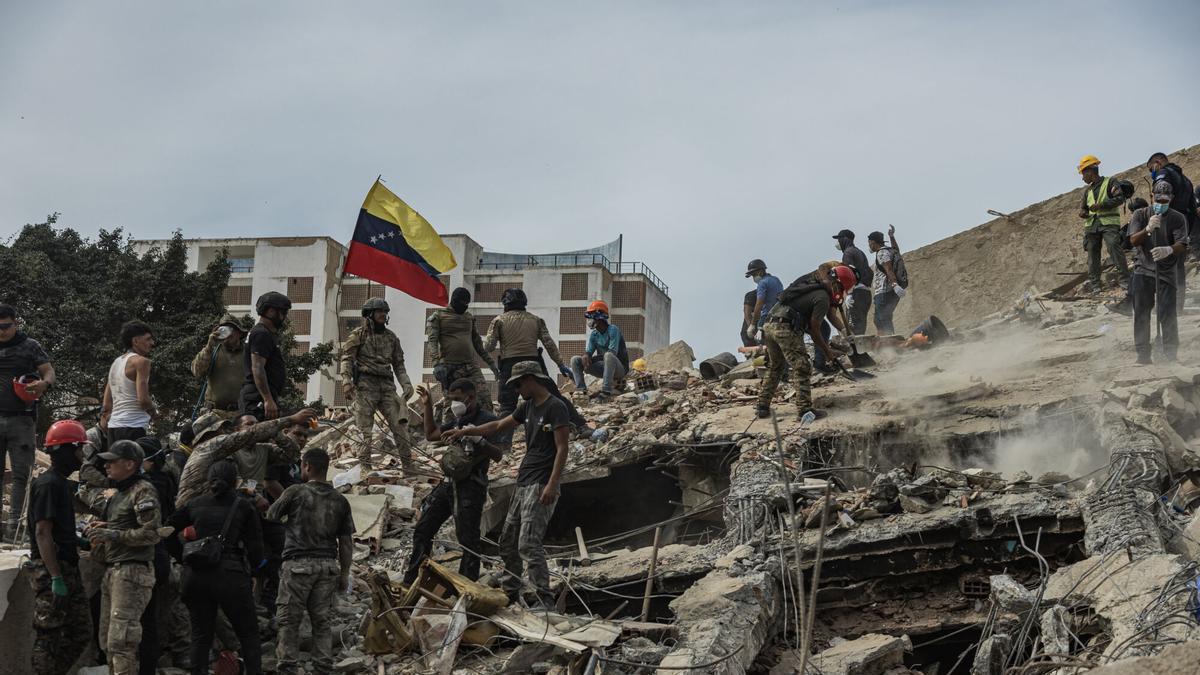 Rescatistas realizan labores de búsqueda de personas desaparecidas en una zona afectada por los terremotos, este domingo, en Tanaguaneras, La Guaira (Venezuela)
