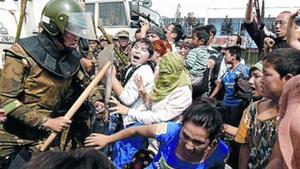 Unas mujeres uigures tratan de romper un cordón policial, ayer.